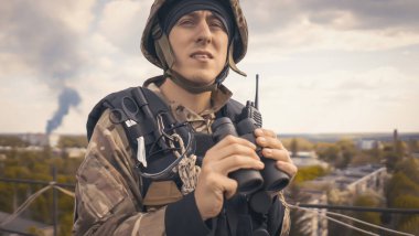 Askeri üniformalı ve kask takan genç bir adam savaş sırasında dürbünle bakar ve askeri tatbikatlara katılır. Asker binanın çatısında keşif görevleri yürütür..