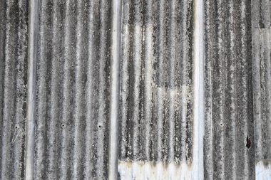 Eski asbest beton çatı çarşafları, asbest çatı kaplaması, Çamurlu Çimento Çarşafı, kıvrımlı paneller, gri yazı tahtası, gri dalgalı çatı deseni arka plan.