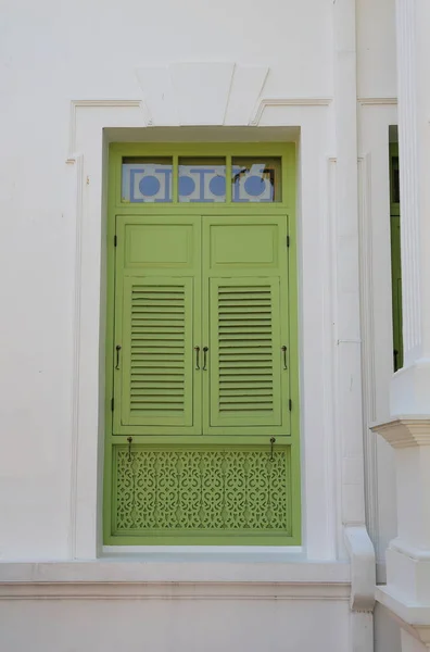 美しい緑の木製の窓とほこりだらけの白い古代の建物のファサード — ストック写真