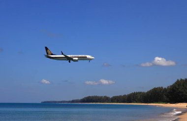 Uçak ya da yolcu uçağı Boing 737 MAX plajın yanındaki havaalanına iniyor. Uçak deniz sahilinde son derece alçaktan uçuyor..