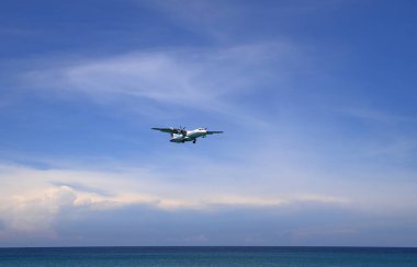 Uçak ya da Yolcu uçağı Bangkok Havayolları ATR 72-600 plajın yanındaki havaalanına iniyor. Uçak deniz sahilinde son derece alçaktan uçuyor..