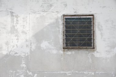 Camdan pencereleri olan tozlu beyaz antik bina cephesi.