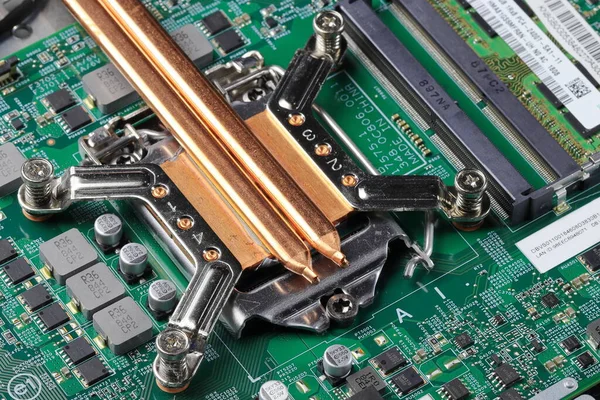 Close up heat sink or heat pipe or computer processor cooler or radiator on notebook computer motherboard made from copper.