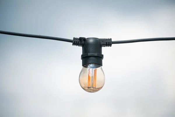 outdoor lighting bulb. a lamp on a wire. many lamps on a wire on a summer terrace in a cafe