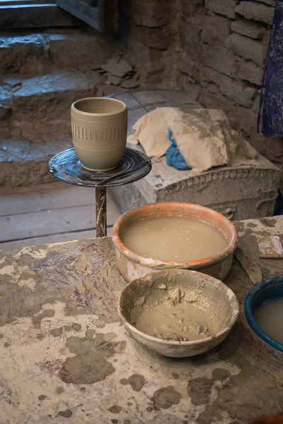 the workplace of a craftsman who makes various clay jugs and dishes