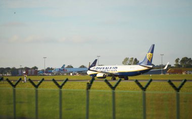 Dubli, İrlanda - 10.11.2021: Dublin havaalanında Ryanair uçağı. Ticari uçak jeti güzel gün batımı ışığında iniyor. Uçuş ulaşımı havayolu arka planı kavramı.