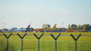 Dubli, İrlanda - 10.11.2021: Dublin havaalanında DHL uçağı. Ticari uçak jeti güzel gün batımı ışığında iniyor. Uçuş ulaşımı havayolu arka planı kavramı.