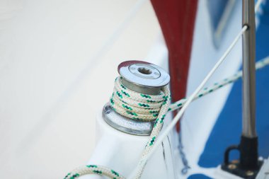 Limandaki yelkenli teknede vinç ve denizcilik halatları.