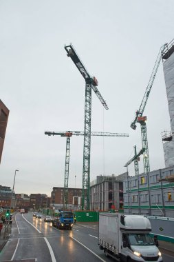 Dublin, İrlanda - 12.03.2021: Dublin 'de bitmeyen inşaat, yeni binalar, ofis inşaatı ve bulutların altında bolca vinç bulunuyor