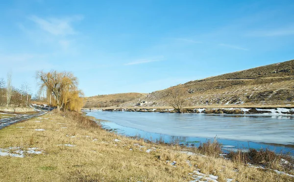 Kışın huş ağacı ve donmuş nehirle güzel doğal manzara.