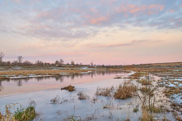 Kışın huş ağacı ve donmuş nehirle güzel doğal manzara.