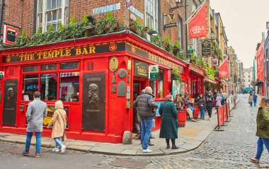 Dublin, İrlanda - 04.10.2022: Temple Bar Dublin 'in kültürel bölgesinde her yıl binlerce turist tarafından ziyaret edilen ünlü bir simgedir. Meyhanedeki insanlar..