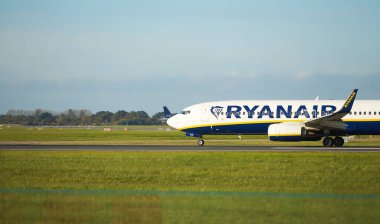 Dubli, İrlanda - 10.11.2021: Dublin havaalanında Ryanair uçağı. Ticari uçak jeti güzel gün batımı ışığında iniyor. Uçuş ulaşımı havayolu arka planı kavramı.