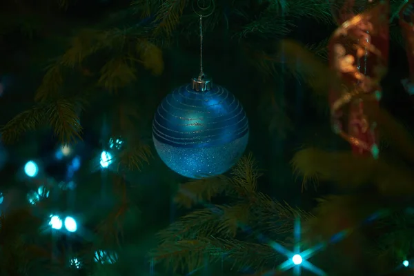 Großaufnahme Von Urlaub Elektrischen Blauen Girlanden Auf Tannenzweig Mit Christbaumschmuck — Stockfoto