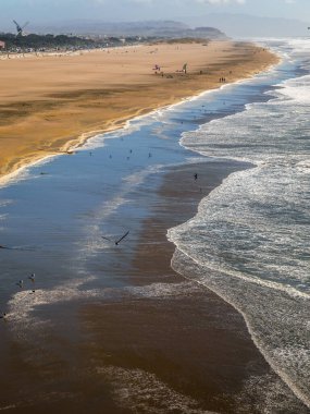 Şiddetli dalgaların sahili ve sahili vurduğu rüzgarlı bir günde Pasifik Okyanusunun doğal manzarası.