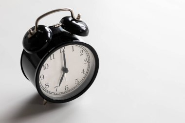 Siyah-beyaz klasik alarm saati saat 7 yönünde, beyaz boşluklu..