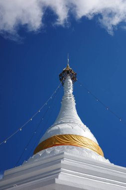 Mae Hong Son vilayetindeki Tayland tapınağının beyaz pagoda 'sı Wat Prathat Doi Kongmu sarı parlak kumaşla kaplanmış ortada mavi gökyüzü ve bulutlar.
