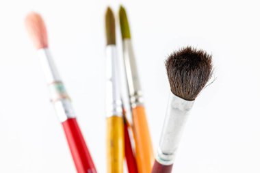 Beyaz arkaplanda suluboya resim yapmak için kullanılan fırçanın saç ucuna yakın odaklan.