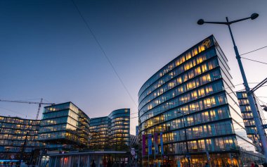 Viyana, Avusturya - 30 Ekim 2019: Kampüsün cam binaları, iş yerleri ve bankalar gün batımında şehrin merkezinde alacakaranlık gökyüzü ile açıldı.