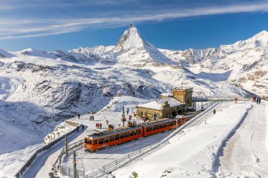 Gornergrat, Zermatt, İsviçre - 12 Kasım 2019: Karlı tren istasyonunda turistler ve Matterhorn zirvesinde kışın
