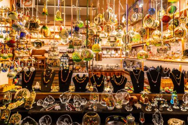 Hallstatt, Avusturya - 1 Kasım 2019: Bir çok renkli hediye ve hediyelik eşya mağazasında parlak ışıkla raftaki camdan yapılmış dekoratif eşyalar.