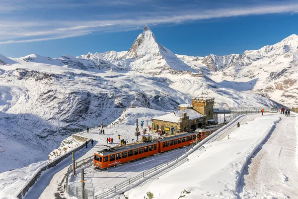 Gornergrat, Zermatt, İsviçre - 12 Kasım 2019: Karlı tren istasyonunda turistler ve Matterhorn zirvesinde kışın