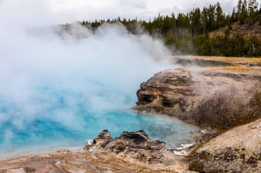 Yellowstone Ulusal Parkı, Wyoming, ABD 'de tehlikeli bölgede beyaz dumanlı kaynayan mavi gölet gayzer havzasının doğal manzarası..