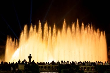 Barcelona, İspanya - 5 Ekim 2018: Kalabalık izleyicilerle çevrili renkli sihir çeşmesinin önünde siluetli insanlar.