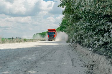 Endüstriyel çöp kamyonu, taşların taşınması, tozlu yolda yolculuk. Kariyer işi
