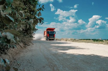Endüstriyel çöp kamyonu, taşların taşınması, tozlu yolda yolculuk. Kariyer işi