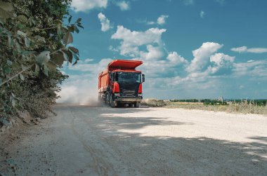 Endüstriyel çöp kamyonu, taşların taşınması, tozlu yolda yolculuk. Kariyer işi