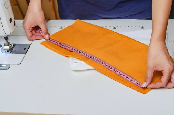 Tissue measurement. Women's hands. Tailoring. Fashionable design.