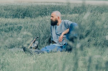 Yaz tarlasında ortaçağ kıyafetleri giymiş bir adamın portresi. Viking zırhı. Metal başlık ve zincir zırh.