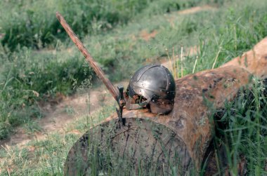 Tahta bir kütüğün üzerinde duran eski Viking zırhının görüntüsü. Kask ve balta. Tarihi fotoğraf konsepti.
