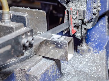 Metal boruları kesme işlemi. Metal işçiliği. Metal tozu.