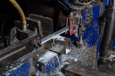 Metal boruları kesme işlemi. Metal işçiliği. Metal tozu.