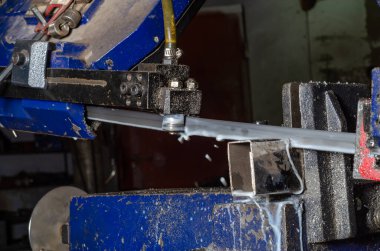 Metal boruları kesme işlemi. Metal işçiliği. Metal tozu.
