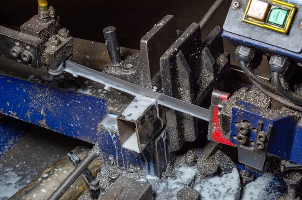 Metal boruları kesmek için bir makine. Kesme işlemi. Metal tozu. Sanayi.