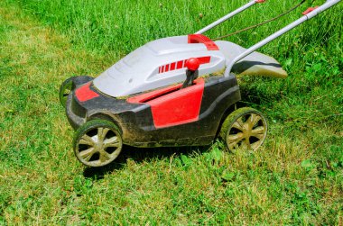 Elektrikli el çim biçme makinesi çim biçer. Yakın plan. Yan görünüm.