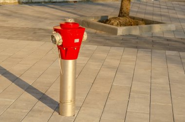 Şehirdeki kaldırımda yangın musluğu var. Yaklaştın. Kırmızı yangın musluğu.