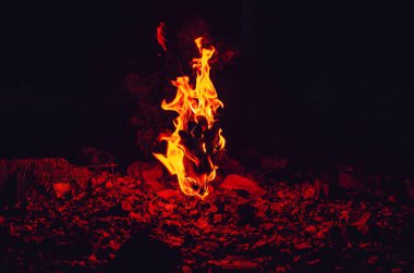 Eldiven alevler içinde kaldı. Gece karanlığında parlak bir ateş.