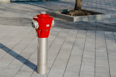 Şehirdeki kaldırımda yangın musluğu var. Yaklaştın. Kırmızı yangın musluğu.