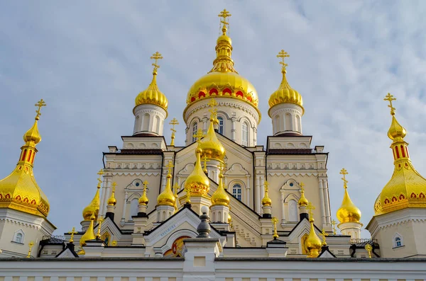 Bulutlu gökyüzüne karşı Ortodoks Hıristiyan dini binasının haçlı altın kubbeleri. Alt manzara. Pochaiv. Ukrayna, 2022