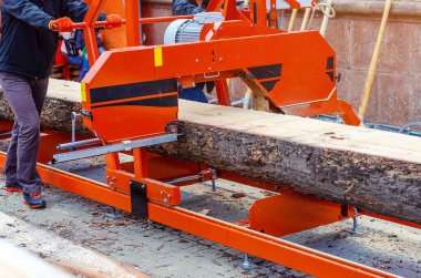 Kütükleri tahtalara kesmek için endüstriyel bir cihaz. Makine günlüklerinin süreci