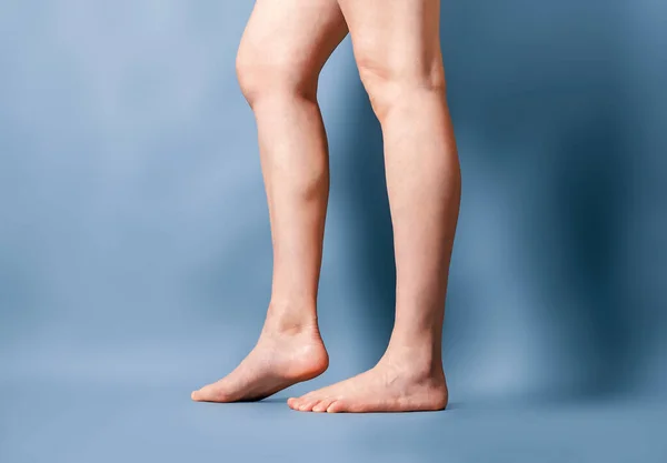 Gri Arka Planda Kadın Uzun Çıplak Bacaklar Ayaklar Parmak Uçlarında — Stok fotoğraf