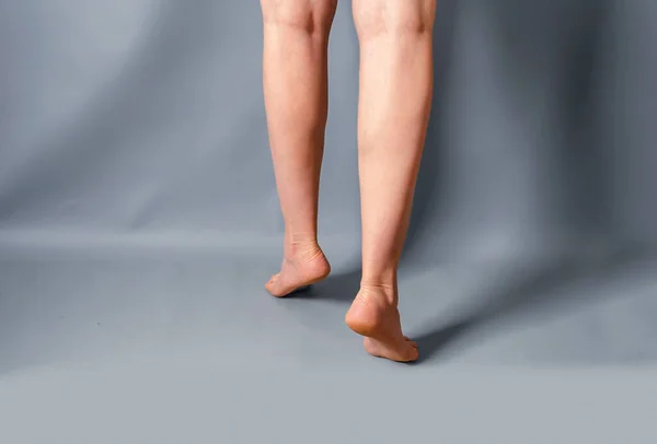 Стрункі Жіночі Ноги Підняті Пальцях Світло Сірому Фоні — стокове фото
