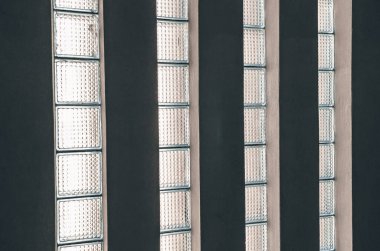 Sovyet tarzı bir evin duvarındaki eski cam bloklar. Dağınık ışık.