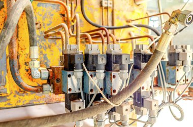 Terk edilmiş paslı makinenin bir parçası. Borular, hortumlar. Eski endüstriyel ekipman.