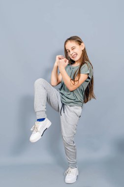 Suratı asık komik bir kız. Küçük kız dövüş teknikleri gösteriyor..