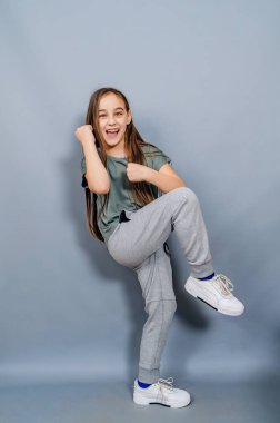 Neşeli küçük kız gülüyor. Küçük kız dövüş teknikleri gösteriyor.